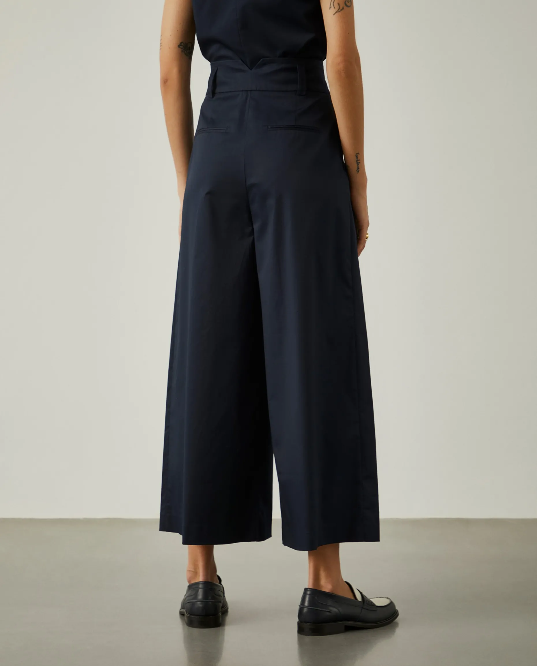 Calças de perna larga com pregas na frente